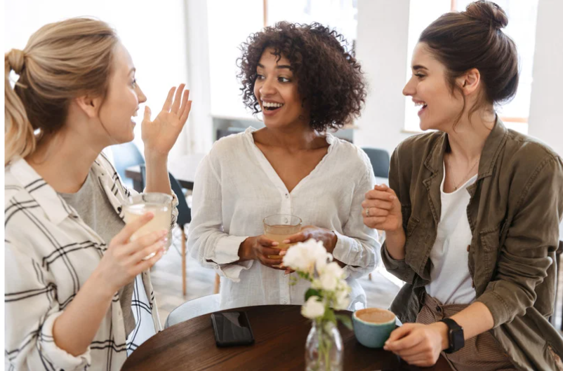 Three women sitting around a table, engaged in conversation.