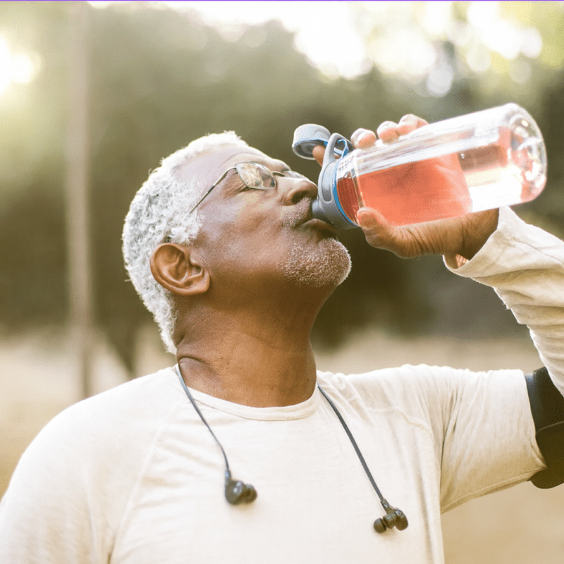 Man drinking from a water bottle outdoors